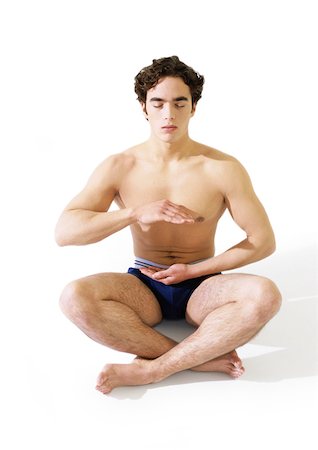 simsearch:695-03385803,k - Man in underwear sitting indian style on floor with hands hovering in front of torso Stock Photo - Premium Royalty-Free, Code: 695-03385806
