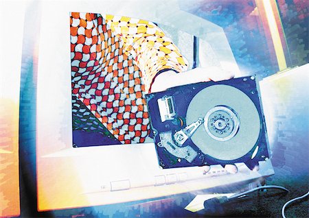 psicodélico - Computer hard disc drive in front of computer monitor, digital composite. Foto de stock - Royalty Free Premium, Número: 695-03385831