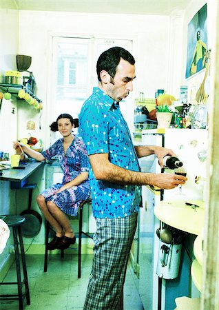 drucken - Couple in kitchen, woman sitting, man pouring wine. Stock Photo - Premium Royalty-Free, Code: 695-03385920