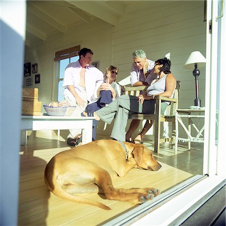 family dog lifestyle - Four people in a room, dog lying on floor Foto de stock - Sin royalties Premium, Código: 695-03386005