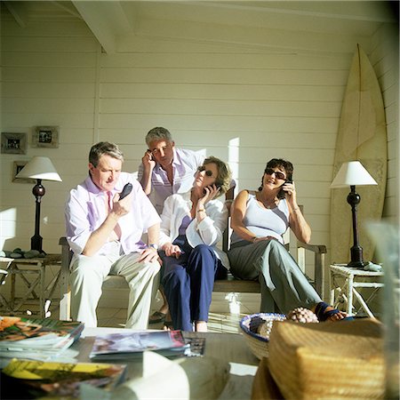 Four people side by side, using phones Stock Photo - Premium Royalty-Free, Code: 695-03386011