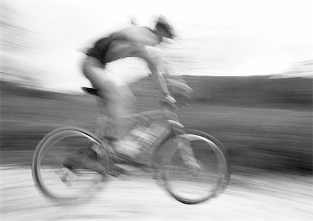 side view of a guy riding a bike - Man cycling, side view, blurred, b&w. Stock Photo - Premium Royalty-Free, Code: 695-03386157