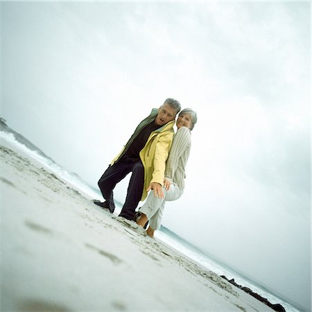 simsearch:649-02732603,k - Mature couple on beach looking down into camera Stock Photo - Premium Royalty-Free, Code: 695-03386180