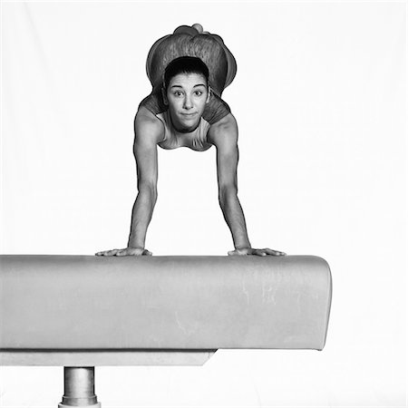 Young woman balancing on beam, looking at camera Stock Photo - Premium Royalty-Free, Code: 695-03386237