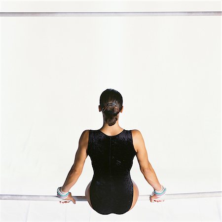 Gymnaste féminine siégeant aux barres asymétriques, vue arrière Photographie de stock - Premium Libres de Droits, Code: 695-03386249