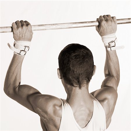 simsearch:632-01145012,k - Male gymnast pulling himself up on horizontal bar, rear view Stock Photo - Premium Royalty-Free, Code: 695-03386241