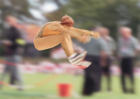 salto em distância - Female long jumper in mid-air, blurred motion Foto de stock - Royalty Free Premium, Número: 695-03386279