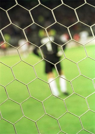 soccer goalkeeper backside - Goal keeper, rear view, blurred, seen from behind the net. Stock Photo - Premium Royalty-Free, Code: 695-03386392
