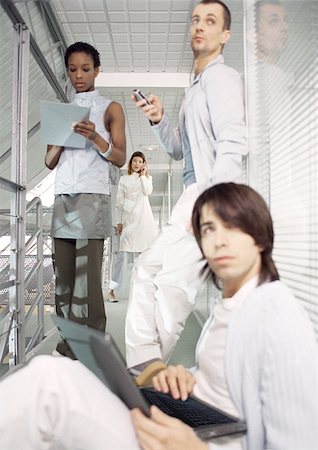 futuristic images of office people at work in the future - Business people working in office hallway Stock Photo - Premium Royalty-Free, Code: 695-03386476