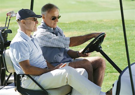 Two mature golfers in golf cart, close-up, side view Stock Photo - Premium Royalty-Free, Code: 695-03386636