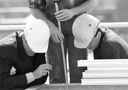 Men wearing hard hats, talking, b&w - Stock Photo - Masterfile