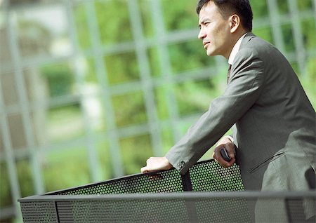 simsearch:632-03403439,k - Businessman leaning on railing, close-up Fotografie stock - Premium Royalty-Free, Codice: 695-03386713