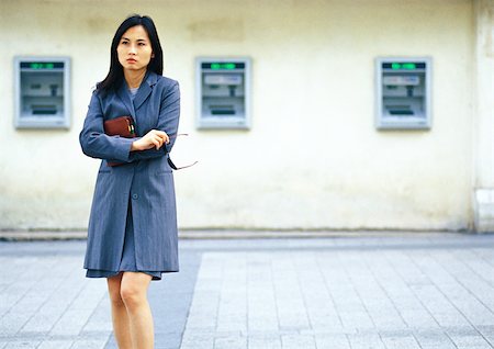 Businesswoman in front of cash machines Stock Photo - Premium Royalty-Free, Code: 695-03386799