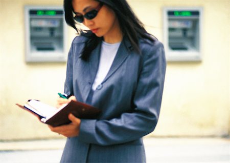 Businesswoman taking notes in the street Fotografie stock - Premium Royalty-Free, Codice: 695-03386805