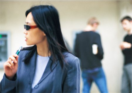 Businesswoman wearing sunglasses, holding pen Fotografie stock - Premium Royalty-Free, Codice: 695-03386803