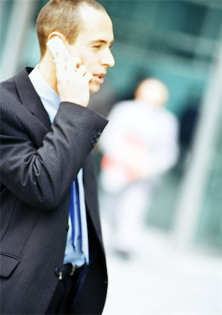 pedestrian side - Businessman using cell phone, side view Stock Photo - Premium Royalty-Free, Code: 695-03386817