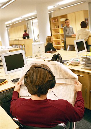 Businessman looking at paper in office, rear view. Stock Photo - Premium Royalty-Free, Code: 695-03386954