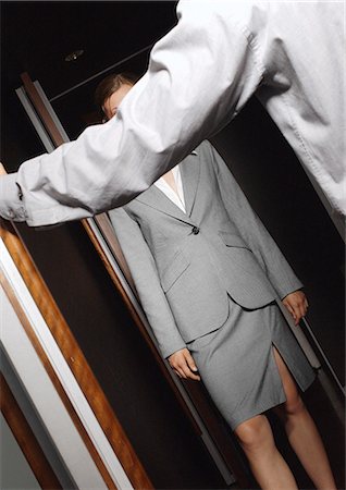 Woman in suit standing in doorway, facing man Stock Photo - Premium Royalty-Free, Code: 695-03387241