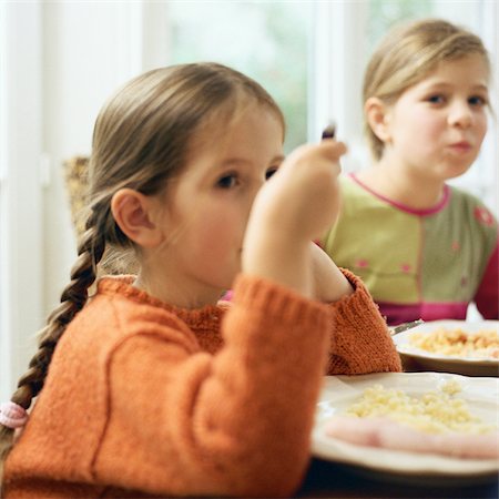 friends table indoor dinner - Two girls sitting at table, eating Stock Photo - Premium Royalty-Free, Code: 695-03387264