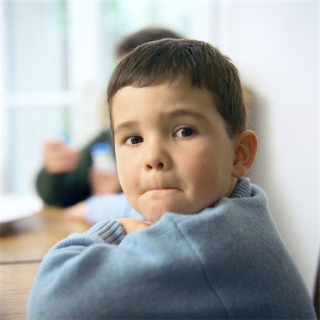 Boy looking over shoulder, portrait, second child in background Fotografie stock - Premium Royalty-Free, Codice: 695-03387269