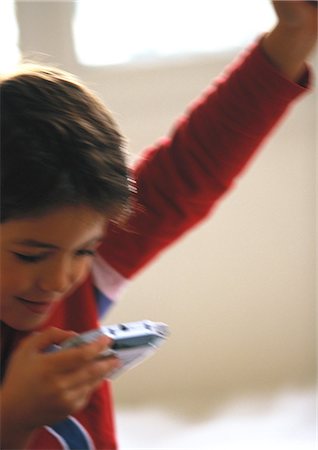 simsearch:673-02140507,k - Young boy playing video game, close up, blurred Foto de stock - Royalty Free Premium, Número: 695-03387284