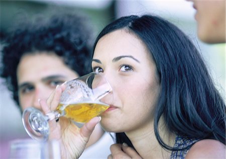 Woman drinking from glass, next to man, close-up Stock Photo - Premium Royalty-Free, Code: 695-03387557