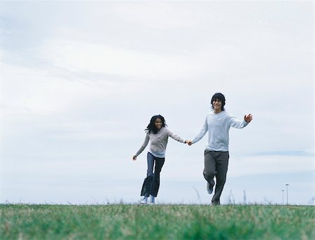 simsearch:695-03373539,k - Young man and woman holding hands and running on grass Stock Photo - Premium Royalty-Free, Code: 695-03388072