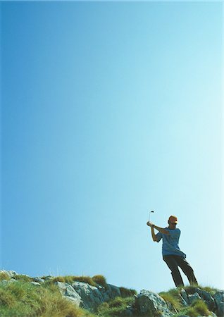 simsearch:6113-07159318,k - Golfer swinging on rugged terrain Stock Photo - Premium Royalty-Free, Code: 695-03388229