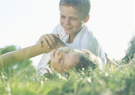 Boy and girl playing in grass Stock Photo - Premium Royalty-Free, Code: 695-03388287