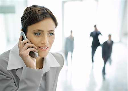 people shocked on phones - Businesswoman using cell phone in office lobby Stock Photo - Premium Royalty-Free, Code: 695-03388338