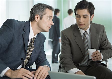 simsearch:695-05779472,k - Two businessmen sitting around laptop, one with coffee cup Stock Photo - Premium Royalty-Free, Code: 695-03388351