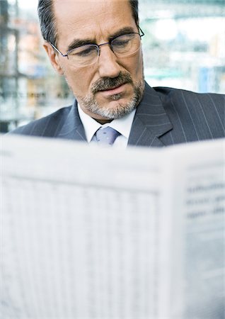 paper moustache - Businessman reading newspaper Stock Photo - Premium Royalty-Free, Code: 695-03388381