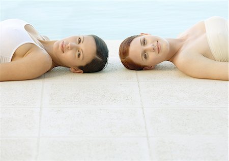 simsearch:695-03377120,k - Two women lying on ground by edge of pool Foto de stock - Royalty Free Premium, Número: 695-03388398