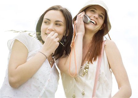 Two young woman outdoors, one using cell phone Stock Photo - Premium Royalty-Free, Code: 695-03388555