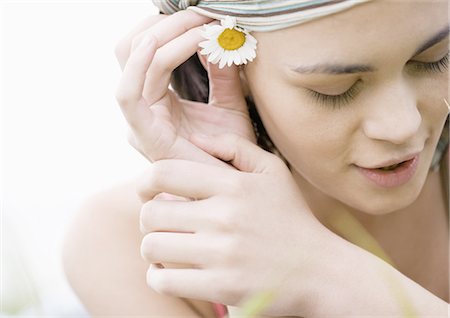 simsearch:695-03388489,k - Young woman putting flower behind ear Fotografie stock - Premium Royalty-Free, Codice: 695-03388553