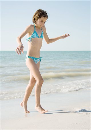 summer beach break - Girl on beach, walking away from water on tiptoes Stock Photo - Premium Royalty-Free, Code: 695-03388643