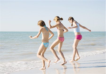 summer beach break - Three girls running toward water on beach Stock Photo - Premium Royalty-Free, Code: 695-03388650