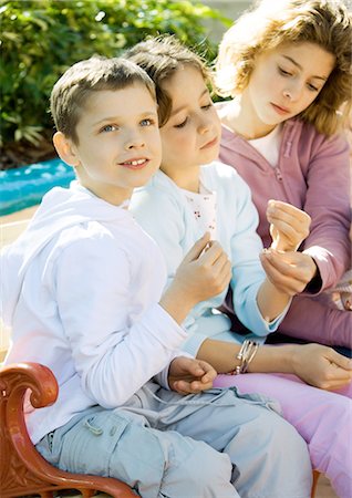 simsearch:632-06030216,k - Children sitting on bench outdoors Foto de stock - Sin royalties Premium, Código: 695-03388797