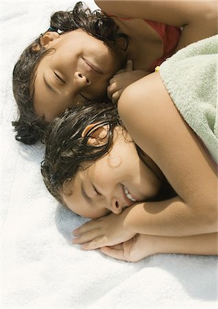 simsearch:695-03380035,k - Two girls lying down together, one wrapped in towel Foto de stock - Royalty Free Premium, Número: 695-03388837