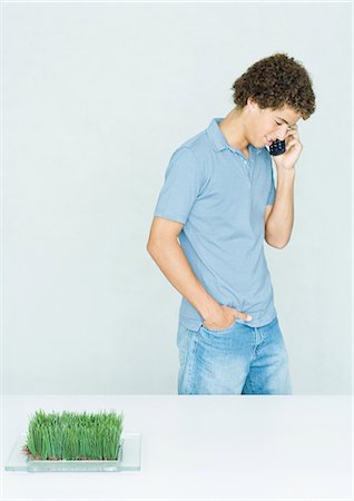 simsearch:695-03374312,k - Man standing using phone, dish of grass growing in foreground Foto de stock - Sin royalties Premium, Código: 695-03388875