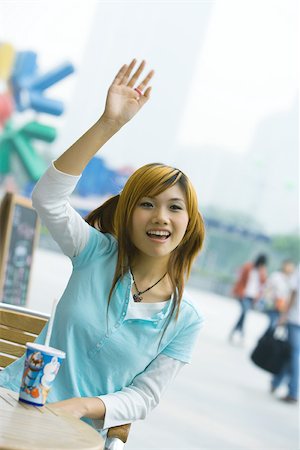 simsearch:6116-07235672,k - Teenage girl sitting outdoors, waving Stock Photo - Premium Royalty-Free, Code: 695-03388887