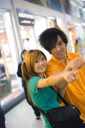 simsearch:632-01271797,k - Teenage couple pointing out of frame Stock Photo - Premium Royalty-Free, Code: 695-03388889