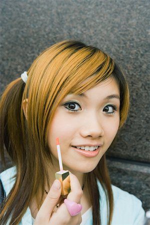 simsearch:855-02989423,k - Teenage girl holding lipgloss wand Foto de stock - Sin royalties Premium, Código: 695-03388905