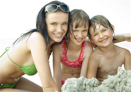 Young woman and two children on beach, smiling at camera Foto de stock - Sin royalties Premium, Código: 695-03388947