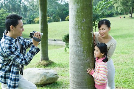 Man videotaping wife and daughter in park Stock Photo - Premium Royalty-Free, Code: 695-03388961