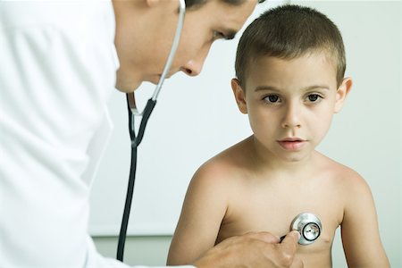 Doctor listening to boy's chest with stethoscope Stock Photo - Premium Royalty-Free, Code: 695-03389035