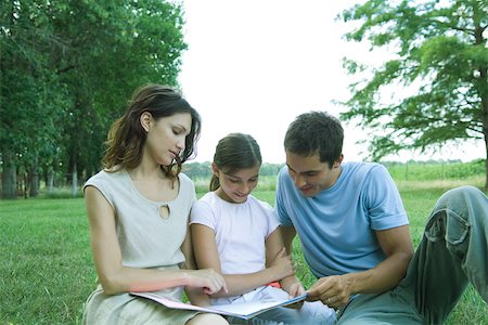 simsearch:400-08891803,k - Girl reading book with parents, sitting on grass Stock Photo - Premium Royalty-Free, Code: 695-03389190