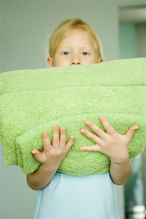 Girl holding stack of folded towels Stock Photo - Premium Royalty-Free, Code: 695-03389251