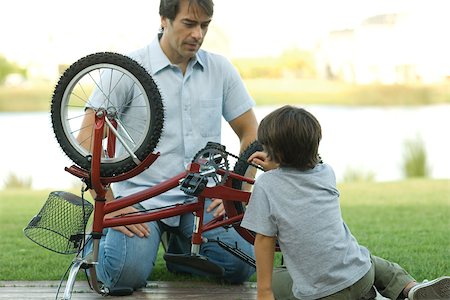 Father and son fixing bike together Stock Photo - Premium Royalty-Free, Code: 695-03389253