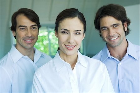 simsearch:695-03376535,k - Businesswoman and two businessmen smiling at camera, head and shoulders, portrait Stock Photo - Premium Royalty-Free, Code: 695-03389338